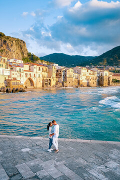 couple on vacation Sicily visiting the old town of Cefalu,sunset at the beach of Cefalu Sicily, old town of Cefalu Sicilia panoramic view at the colorful village.Italy