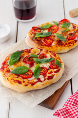 Italian focaccia or pizza with mozzarella, tomatoes and basil. Healthy eating. Vegetarian food.