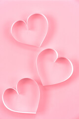 Paper cut hearts on pastel pink background. Composition for Valentine's Day, postcard. Flat lay, top view, copy space.
