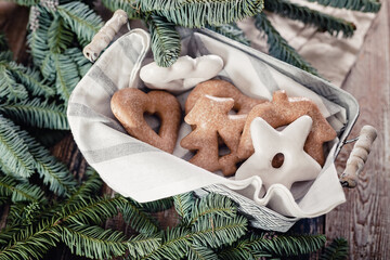 Gingerbread Christmas cookies and green fir branches on a rustic table. Homemade traditional New Year or Christmas sweet pastries. Top view