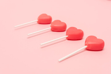 heart shaped lollipops on pink background