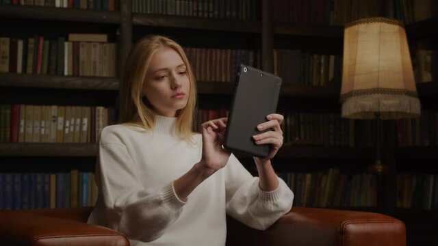 Young blond caucasian model painting on a tablet