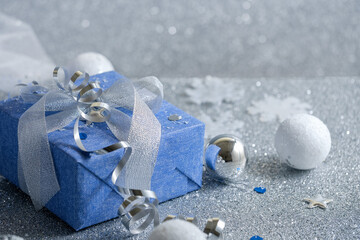 Christmas gift wrapped in paper on a silver background with bokeh