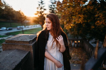 portrait of red-haired young woman in autumn in the park with beautiful healthy hair
