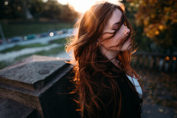 portrait red-haired young woman in autumn in the park with beautiful healthy hair