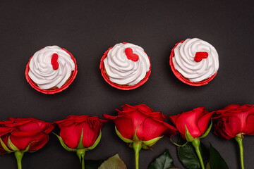 top view of roses and cupcakes isolated on black