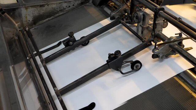 Printing machine print paper in typography. Newspaper or tabloid print on plant factory, conveyor belt line after printing