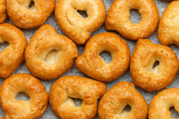 Tarallini-traditional Italian small bagels. Taralli. Delicious snack close-up. Culinary background. Selective focus, top view