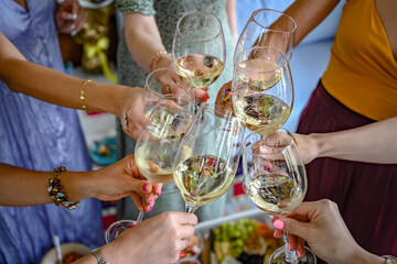 Ladies hands raising the glasses with wine for a toast