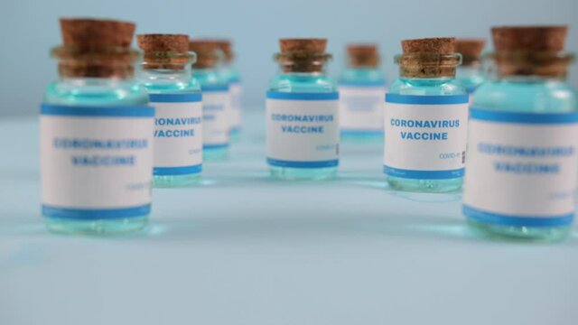 Syringe needle, a drop liquid, blurred pfizer company on the blue background. Coronavirus vaccine concept. Covid-19 inoculation jointly developed. Ready-made preparations with doses