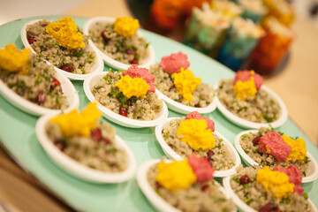 Finger food Quinoa Bowl with pink and yellow humus on a plate