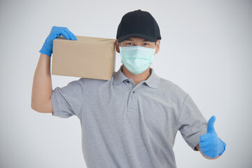 Fototapeta na wymiar Delivery driver man in uniform with surgical mask hold boxes - isolated on white background