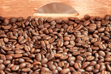 A wooden box full of roasted coffee beans.