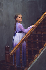 Fototapeta na wymiar Caucasian girl in a pink purple dress posing on wooden stairs