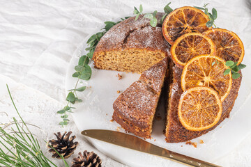 Christmas orange and spice cake. Decorated with dried oranges on kitchen countertop