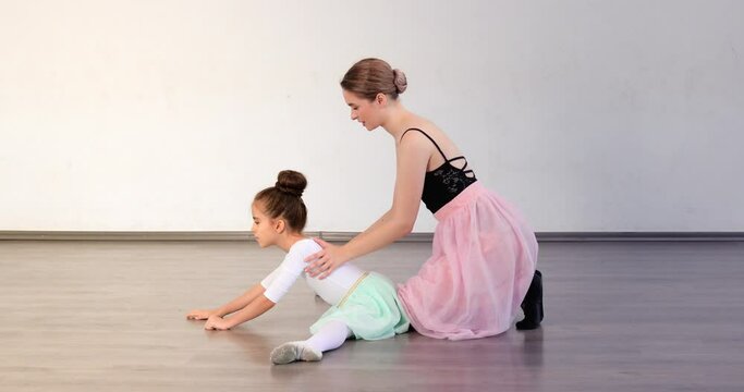 Little ballerina training with coach in dance studio