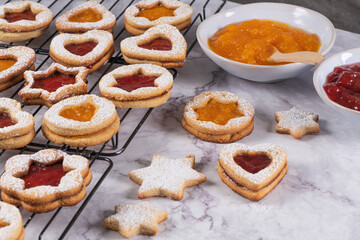 Tasty homemade Christmas cookies. Traditional Austrian christmas cookies - Linzer biscuits filled with red raspberry jam and punpkin jam. Festive decoration. Homemade bakery. Flat lay, top view