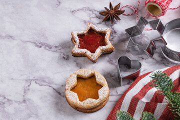 Tasty homemade Christmas cookies. Traditional Austrian christmas cookies - Linzer biscuits filled with red raspberry jam and punpkin jam. Festive decoration. Homemade bakery. Flat lay, top view
