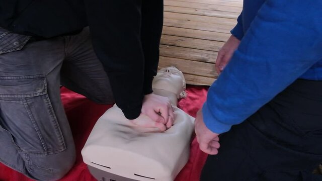 Practicing first aid on mannequin. Practice how to make chest compressions on dummy during the first aid training outdoors.