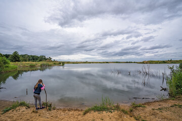 Female girl standing by a pond at sunrise