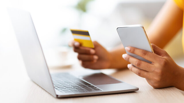 Black Lady Using Smartphone And Credit Card Sitting At Desk