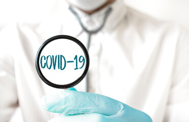 Doctor holding a stethoscope with text COVID 19, medical concept