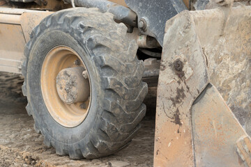 Fototapeta na wymiar Muddy excavator wheel at the construction site.