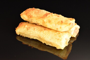 Several mini strudel with an apple, close-up, on a black background.
