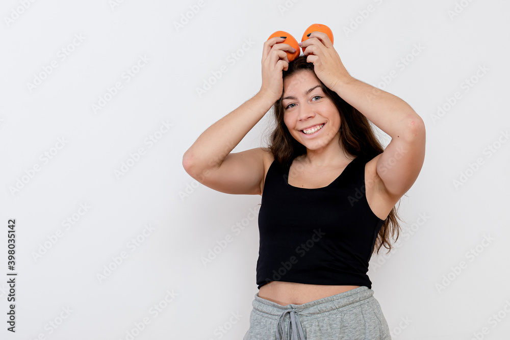 Wall mural charming young attractive teenager girl with orange fruits in hands, isolated on white background