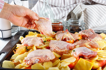 Man cooks chicken with vegetables and spices