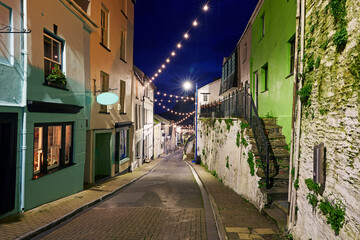 Long exposure image of the small North Devon fishing village of Ilfracombe with the historic 'Fore Street' illuminated at dusk with festive christmas lights