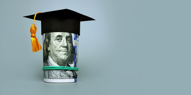 Loan or savings for college. Graduation cap and roll of cash.