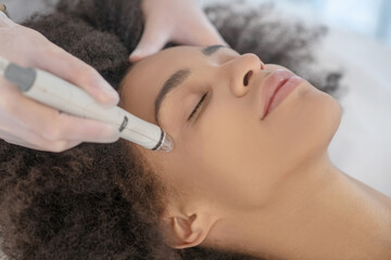 Doctor hands performing hardware cosmetic procedure on girl face
