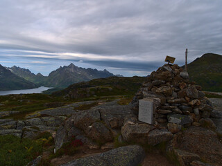 Peak of Keiservarden with rock pile and historic plaque with majestic mountains near Digermulen, Hinnøya, Vesterålen, Norway. Text: German Emperor Wilhelm II visited this place (Vardene) in 1903.