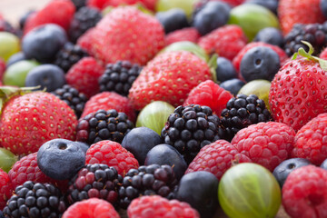 Ripe berries mix of strawberries, blackberries, raspberries, blueberries and gooseberries. Selective focus.