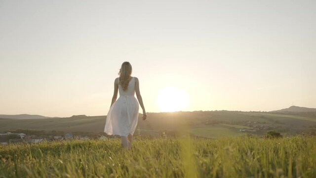 girl in white dress plays with her hands and sunlight