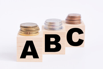 wooden cubes with the letters ABC and coins on top . Business.