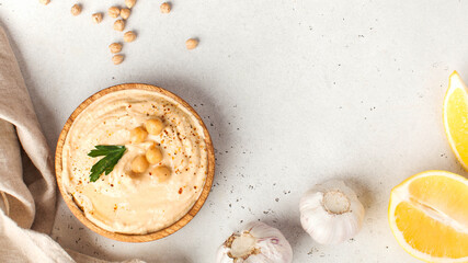 Hummus in a wooden plate with parsley. Dishes of chickpeas, a vegetarian dish. Copy space.