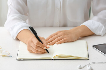 Woman writing in notebook with pen