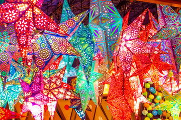 Paper bright multi-colored stars on christmas sale and New Year stars decorations.