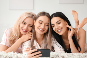 Beautiful young women taking selfie at slumber party