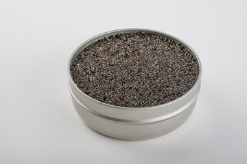 Obraz na płótnie Canvas Black caviar of sturgeon in a jar on a gray background. Decoration New Year's table