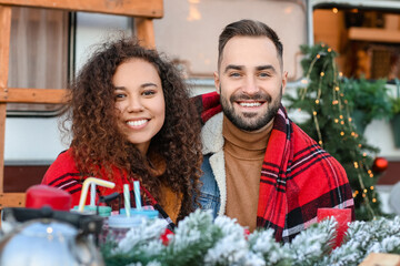 Happy young couple celebrating Christmas outdoors