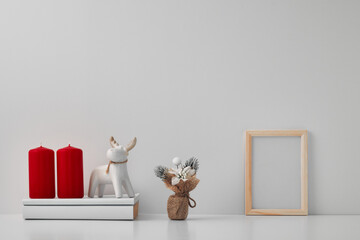 Porcelain figurine of a deer and New Year's decor and candles. Copy space, mock up.
