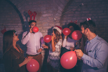 Friends blowing balloons at New Year's party