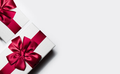 Close-up of gift box with red bow on white background with copy space.