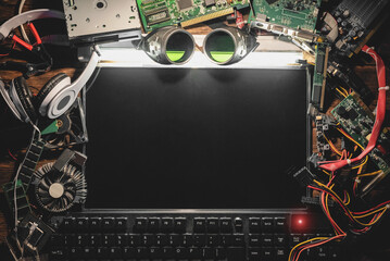 Blank screen computer display and old comnputer parts on the flat lay table background.