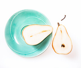 halved pear on a green plate