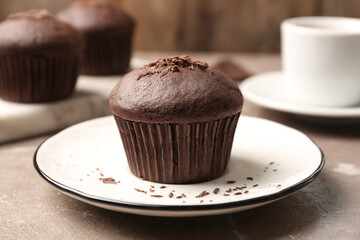 Delicious cupcake with chocolate crumbles on beige marble table, closeup