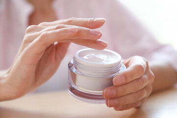 Woman with jar of moisturizing cream, closeup